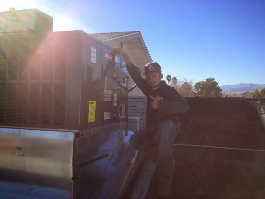 HVAC technician performing Air Duct Cleaning on a rooftop unit in Oxford